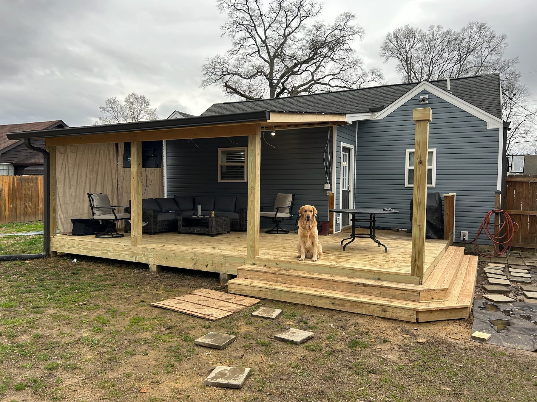 A golden retriever sitting on a newly built covered deck